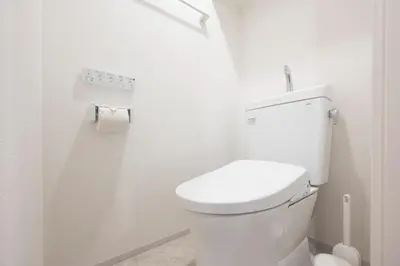 a white bathroom with a toilet and a roll of toilet paper at \u30a2\u30a4\u30c7\u30a3\u84b2\u7530\u897f in Tokyo