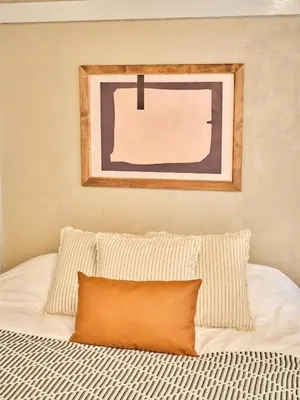 a bed with an orange pillow on top of it at \u548c\u6c23\u4f1a\u3005\u91ce\u65b9 Wakiaiai Nogata in Tokyo