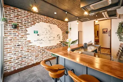 a kitchen with a brick wall and a counter at \u548c\u6c23\u4f1a\u3005\u91ce\u65b9 Wakiaiai Nogata in Tokyo