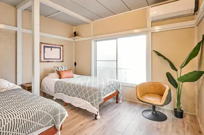 a bedroom with a bed and a chair and a window at \u548c\u6c23\u4f1a\u3005\u91ce\u65b9 Wakiaiai Nogata in Tokyo