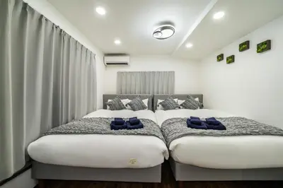 two beds in a bedroom with blue pillows on them at 66, Omori-Nishi, Entire house for rent, \u5927\u68ee\u897f in Tokyo