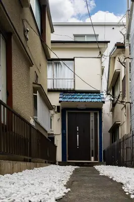 a building with a door in a snowy alley at 66, Omori-Nishi, Entire house for rent, \u5927\u68ee\u897f in Tokyo