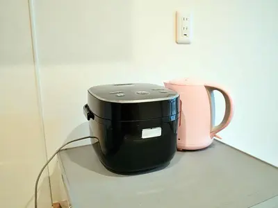 a black coffee pot sitting on a glass table next to a pink appliance at Mamada Building - Vacation STAY 16945 in Tokyo