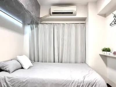 a bedroom with a bed with a air conditioner at Ikebukuro Sugamo \u99c5\u8fd1 A4 in Tokyo
