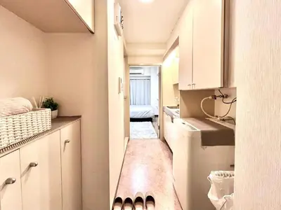 a small kitchen with white cabinets and a washer and dryer at Ikebukuro Sugamo \u99c5\u8fd1 A4 in Tokyo