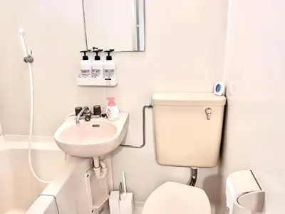a white bathroom with a toilet and a sink at Ikebukuro Sugamo \u99c5\u8fd1 A4 in Tokyo