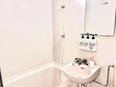 a white bathroom with a sink and a mirror at Ikebukuro Sugamo \u99c5\u8fd1 A4 in Tokyo