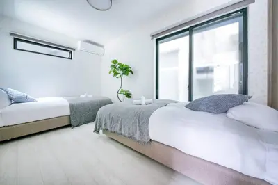 a bedroom with two beds and a large window at \u3077\u3075\u304b\u6771\u5411\u5cf63 in Tokyo