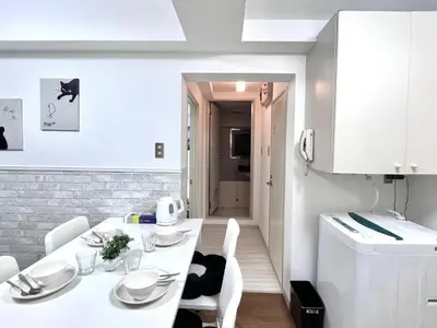 a white kitchen with a white table and white chairs at Ikebukuro Sugamo \u99c5\u8fd1 C02 in Tokyo