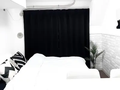 a bedroom with a white bed and a black curtain at Ikebukuro Sugamo \u99c5\u8fd1 C02 in Tokyo