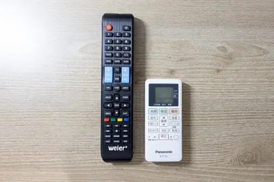 a remote control and a cell phone sitting on a table at \u30ec\u30d4\u30e5\u30a2\u897f\u843d\u5408\u30ec\u30b8\u30c7\u30f3\u30b9 in Tokyo