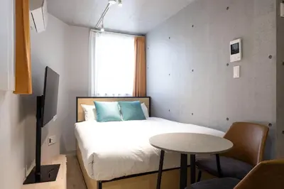 a bedroom with a bed and a table and a window at \u30ec\u30d4\u30e5\u30a2\u897f\u843d\u5408\u30ec\u30b8\u30c7\u30f3\u30b9 in Tokyo