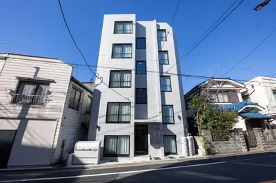 a white building on the side of a street at \u30ec\u30d4\u30e5\u30a2\u897f\u843d\u5408\u30ec\u30b8\u30c7\u30f3\u30b9 in Tokyo