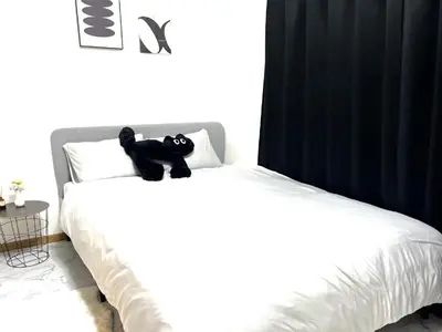 a black teddy bear sitting on top of a bed at \u6c60\u888b\u96fb\u8eca2\u5206 2Rooms in Tokyo