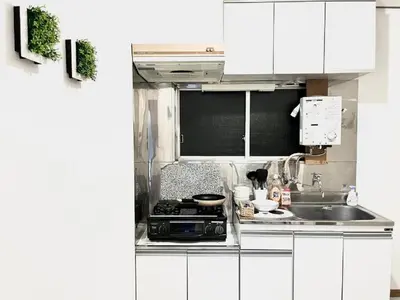 a kitchen with white cabinets and a stove and a sink at \u6c60\u888b\u96fb\u8eca2\u5206 2Rooms in Tokyo