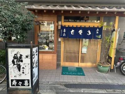 a store with a sign in front of a building at \u65b0\u5c0f\u5ca9\u9a7f\u7ad9 in Tokyo