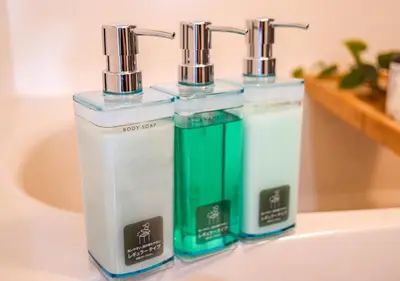 three bottles of soap sitting on top of a sink at Asakusabashi Condominium Hotel in Tokyo