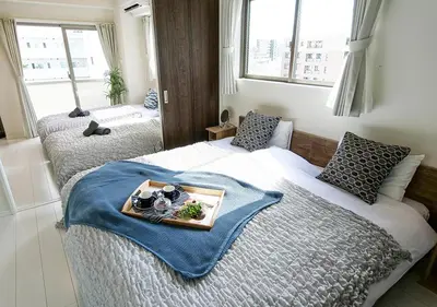 a bedroom with two beds with a tray of food on it at Asakusabashi Condominium Hotel in Tokyo