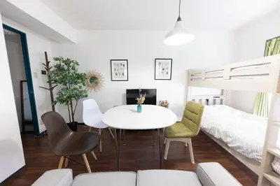 a living room with a table and chairs and a bed at TRIP PERCH 30m2 \u6700\u59275\u540d \u4e0a\u5317\u6ca2\u99c5\u304b\u3089\u5f92\u6b696\u5206 \u65b0\u5bbf\u304b\u3089\u76f4\u901a \u30c7\u30b6\u30a4\u30ca\u30fc\u76e3\u4fee in Tokyo