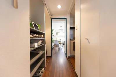 a hallway with a door open to a room at TRIP PERCH 30m2 \u6700\u59275\u540d \u4e0a\u5317\u6ca2\u99c5\u304b\u3089\u5f92\u6b696\u5206 \u65b0\u5bbf\u304b\u3089\u76f4\u901a \u30c7\u30b6\u30a4\u30ca\u30fc\u76e3\u4fee in Tokyo