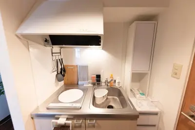 a small kitchen with a sink and a counter at TRIP PERCH 30m2 \u6700\u59275\u540d \u4e0a\u5317\u6ca2\u99c5\u304b\u3089\u5f92\u6b696\u5206 \u65b0\u5bbf\u304b\u3089\u76f4\u901a \u30c7\u30b6\u30a4\u30ca\u30fc\u76e3\u4fee in Tokyo