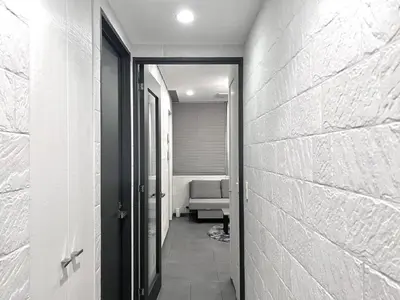 a hallway leading to a room with a couch at Shibuya Harajuku Big House in Tokyo