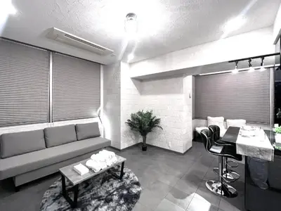 a living room with a couch and a table at Shibuya Harajuku Big House in Tokyo
