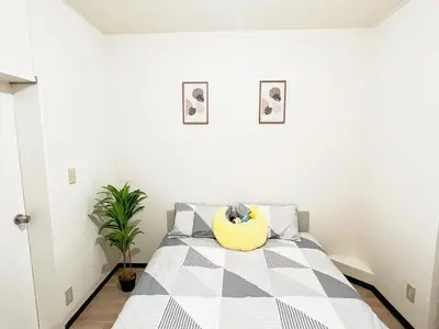 a bedroom with a bed with a yellow pillow on it at \u6c60\u888b\u96fb\u8eca2\u52063Room 6\u4eba\u53ef in Tokyo