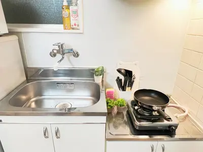 a kitchen with a sink and a frying pan on a stove at \u6c60\u888b\u96fb\u8eca2\u52063Room 6\u4eba\u53ef in Tokyo