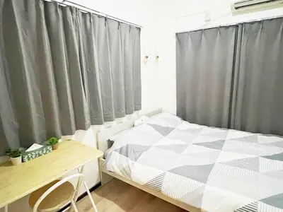 a bedroom with a bed and a desk and curtains at \u6c60\u888b\u96fb\u8eca2\u52063Room 6\u4eba\u53ef in Tokyo