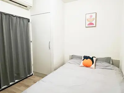 a bedroom with a bed with an orange pillow on it at \u6c60\u888b\u96fb\u8eca2\u52063Room 6\u4eba\u53ef in Tokyo