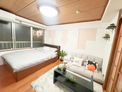 a living room with a bed and a couch at \u9ad8\u7530\u99ac\u58344\u5206 4\u4eba\u53ef 203 in Tokyo