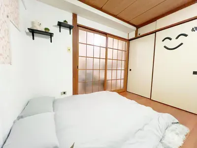 a bedroom with a bed and sliding doors at \u9ad8\u7530\u99ac\u58344\u5206 4\u4eba\u53ef 203 in Tokyo