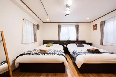 two beds in a room with white walls and windows at 50, Nakano 1, Entire house for rent, \u4e2d\u91ce1\u4e01\u76ee in Tokyo