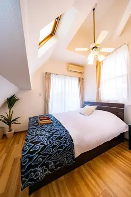 a bedroom with a large bed and a ceiling fan at 50, Nakano 1, Entire house for rent, \u4e2d\u91ce1\u4e01\u76ee in Tokyo