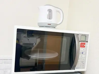 a white appliance sitting on top of a microwave at \u897f\u6b66\u65b0\u5bbf\u7dda\u99c5\u8fd14\u4eba\u53ef 02 in Tokyo