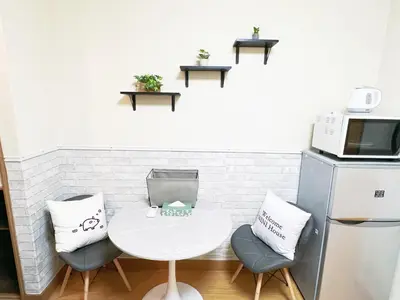 a kitchen with a table and two chairs and a microwave at \u897f\u6b66\u65b0\u5bbf\u7dda\u99c5\u8fd14\u4eba\u53ef 02 in Tokyo