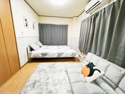 a living room with a bed and a couch at \u897f\u6b66\u65b0\u5bbf\u7dda\u99c5\u8fd14\u4eba\u53ef 02 in Tokyo
