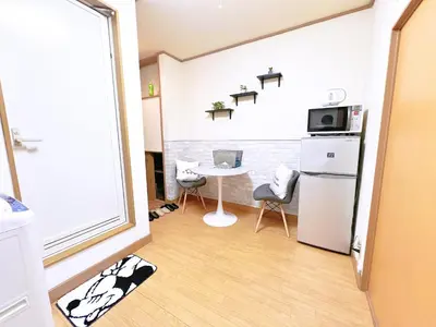 a small kitchen with a table and a refrigerator at \u897f\u6b66\u65b0\u5bbf\u7dda\u99c5\u8fd14\u4eba\u53ef 02 in Tokyo