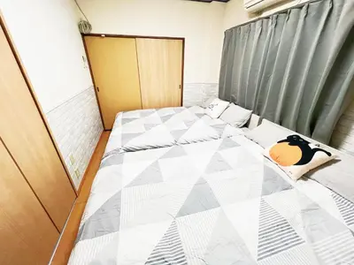 a small bedroom with a bed with a quilted at \u897f\u6b66\u65b0\u5bbf\u7dda\u99c5\u8fd1 6\u4eba\u53ef b1 in Tokyo