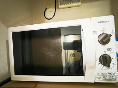 a microwave oven with its door open on a wall at \u5927\u585a\u99c55\u52064\u4eba\u53ef in Tokyo
