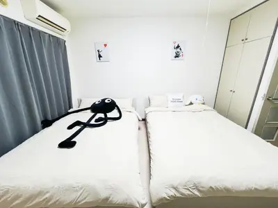 a bedroom with two beds with white sheets at \u5927\u585a\u99c55\u52064\u4eba\u53ef in Tokyo