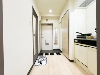 a hallway with a kitchen with a dog rug on the floor at \u5927\u585a\u99c55\u52064\u4eba\u53ef in Tokyo