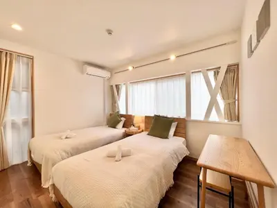 two beds in a room with a window at MX Hotel Roppongi in Tokyo