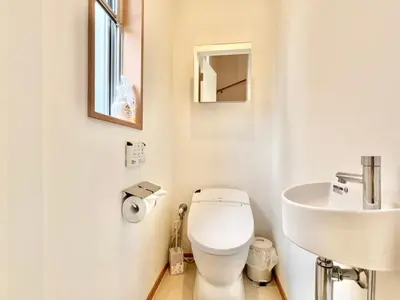 a white bathroom with a toilet and a sink at MX Hotel Roppongi in Tokyo