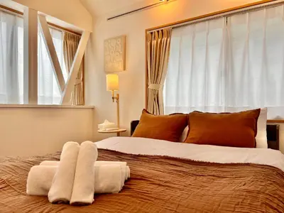 a bedroom with a large bed with towels on it at MX Hotel Roppongi in Tokyo
