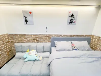 two stuffed animals sitting on a bed in a bedroom at Ikebukuro Sugamo \u6700\u59274\u4ebaB5 in Tokyo