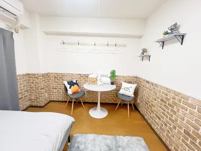 a bedroom with a brick wall and a table and chairs at Ikebukuro Sugamo \u6700\u59274\u4ebaB5 in Tokyo