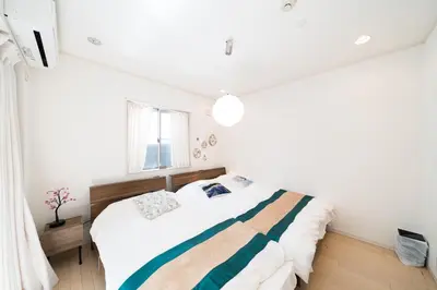 a bedroom with a bed with a striped blanket at 65, Simotakaido A, Entire house for rent, \u4e0b\u9ad8\u4e95\u6238A in Tokyo