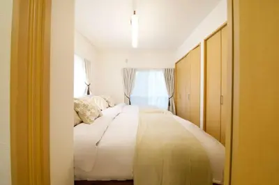 a bedroom with a large white bed with a window at \u30cf\u30a4\u30b0\u30ec\u30fc\u30c9\u7acb\u77f3 101 in Tokyo